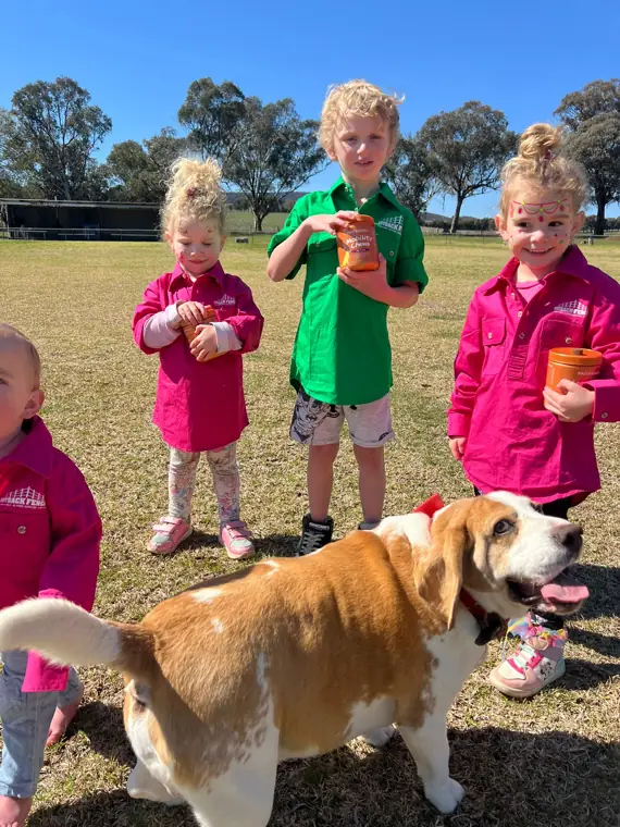Kids holding Bestie Bites jars with a beagle